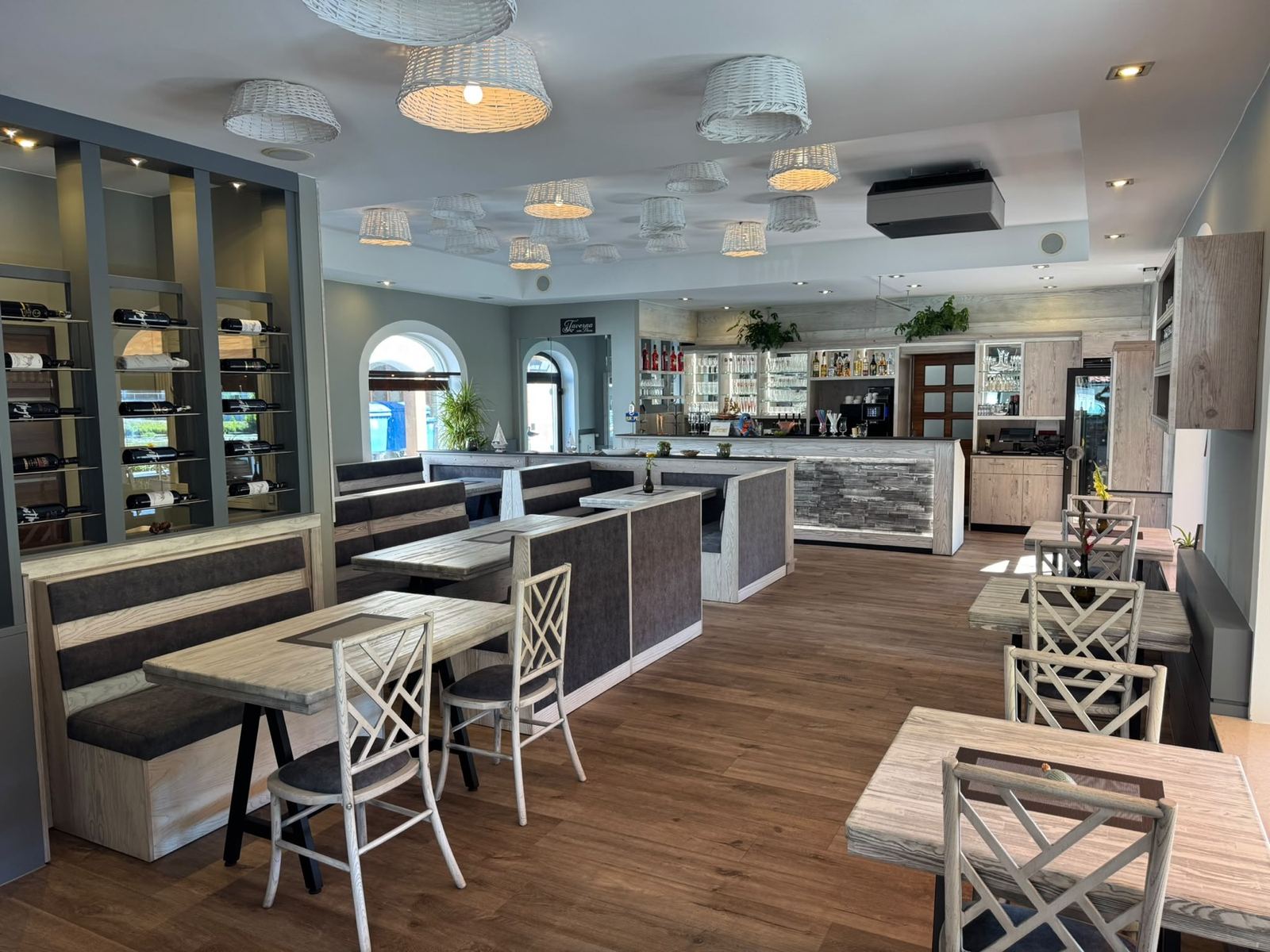 Heller Gastraum mit Weinregal und Blick zur Bar