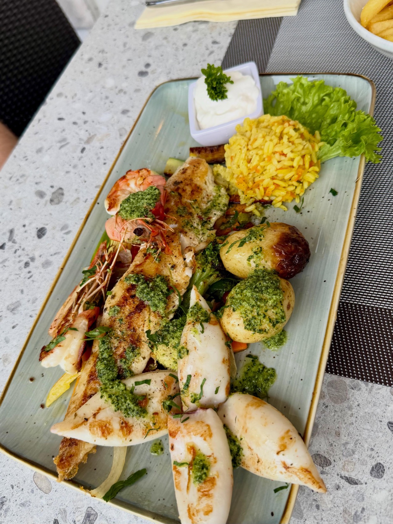 Gegrillte Meeresfrüchte-Platte mit Gambas, Calamari, Fisch, jungen Kartoffeln und Safranreis
